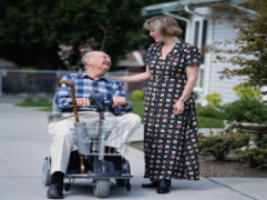 a woman talking with an ederly man in a motorized cart